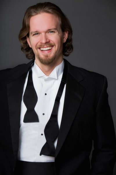 Gabriel Preisser, smiling in a tux with an untied bowtie hanging around his neck.