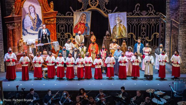 The cast of Opera Las Vegas's "Tosca" gathers on stage in front of a large golden gate and religious paintings to sing the "Te Deum."