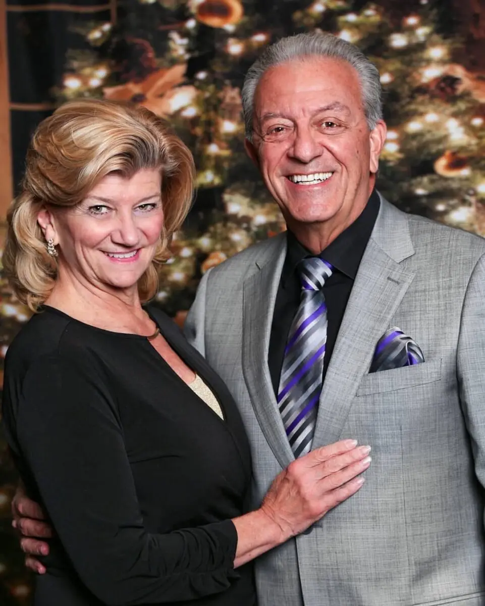 Angelo and Nancy Cassaro in formal attire at a festive Christmas event.