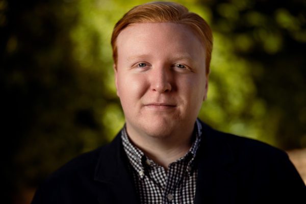 Collin Salmon, a red-headed gentleman in a dark jacket and button-up shirt.