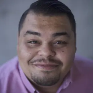Perry Chacon, close up photo of a Latino man in a pink collared shirt.