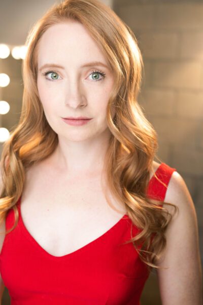 Kayla Wilkens in a formal dress and dramatic lighting.