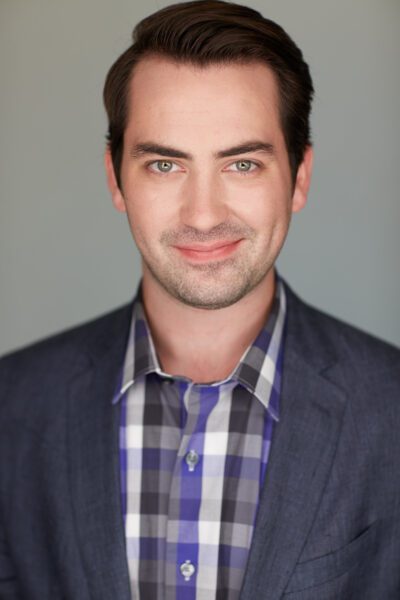 Brian Wallin, tenor, studio photo in business casual attire.