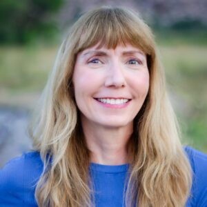 Linda Lister smiles in a casual outdoor setting.