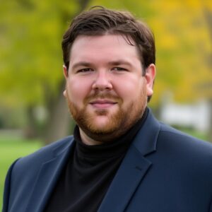 William McCullough, a large Caucasian man dressed in a dark-colored day suit in an outdoor setting.