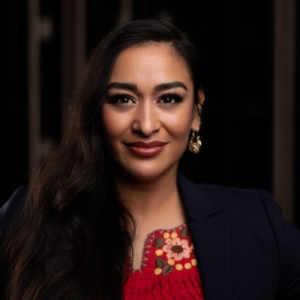 Cecilia Violetta Lopez's professional headshot, showing her dressed in colorful but professional attire and smiling gently at the camera.